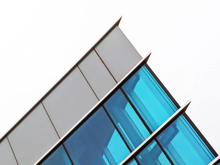 Spacious and contemporary office interior with glass partitions, stylish furniture, and vibrant wall art.